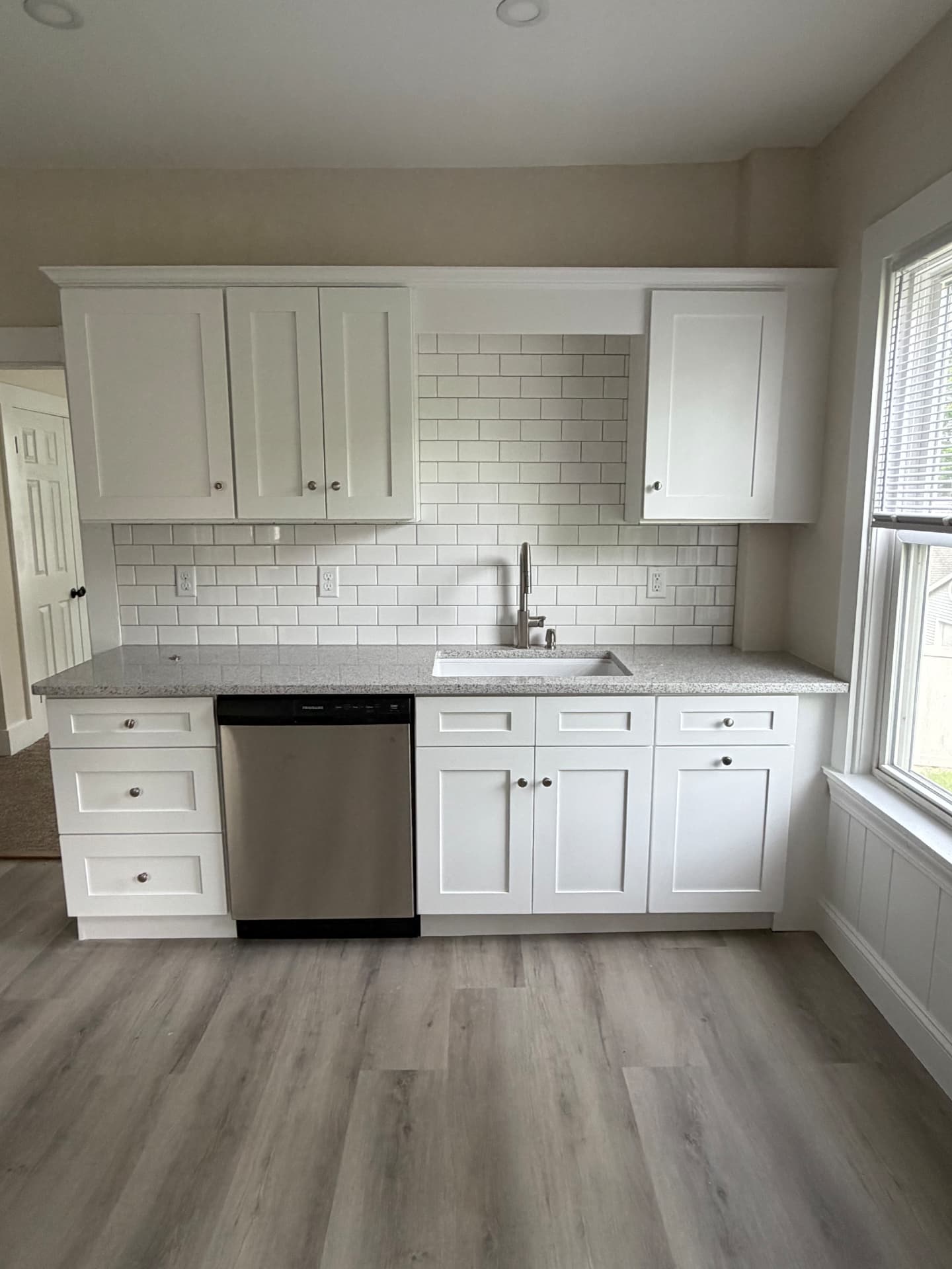 New pull-down kitchen faucet and undermount sink installed beside a stainless steel dishwasher